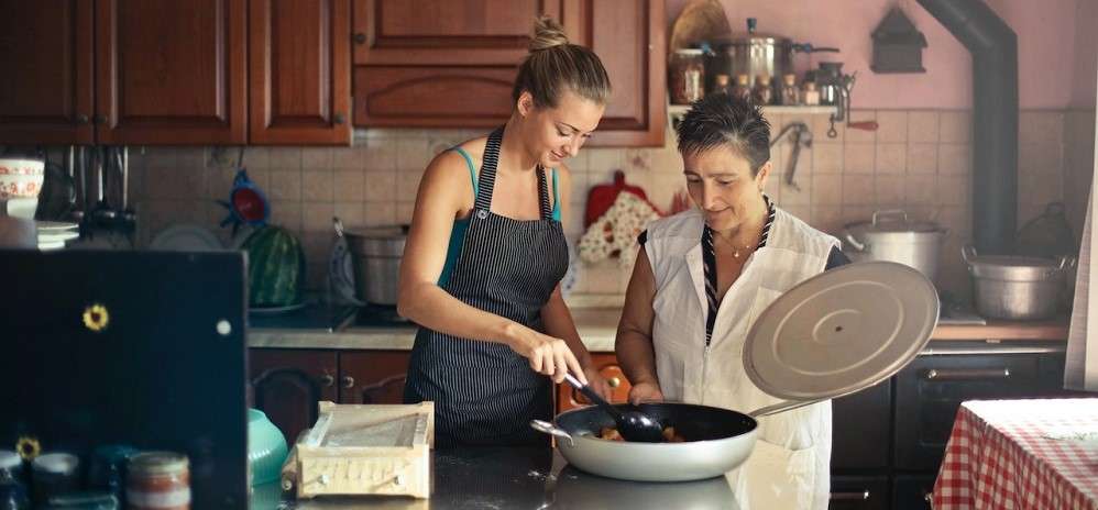 2 ladies cooking a meal at home