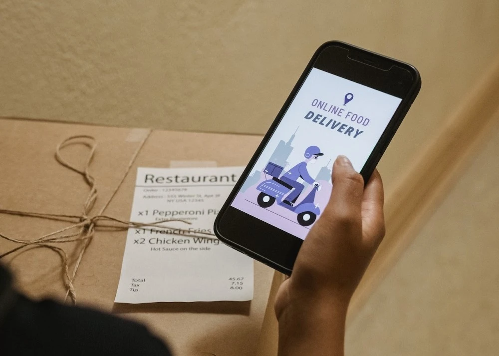 person holding a phone with a food delivery app.
