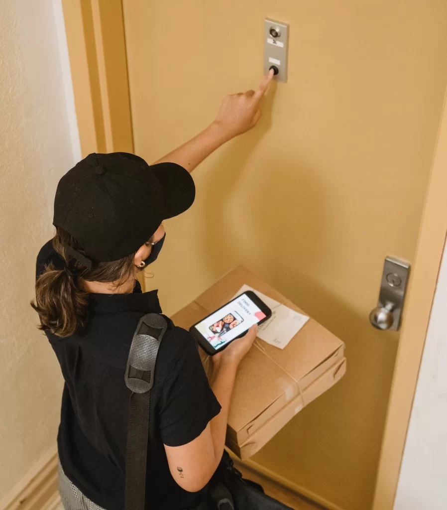 person ringing doorbell with food delivery